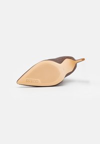 Brun stofhøjhælet sko med spids tå og tekstureret overdel. Har en glat tan gummisål med ribbet mønster for greb.