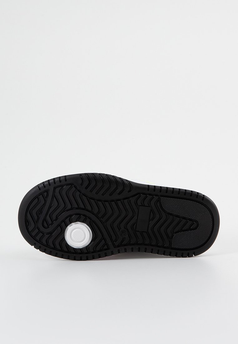 Podeszwa sneakerów w czarnym gumowym materiale z teksturowanym wzorem, z okrągłym białym akcentem na pięcie oraz gładką centralną częścią.