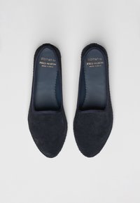 Navy blue suede slip-on shoes with a smooth inner lining, rounded toe, and stitched edges. Labels display brand and country of manufacture.