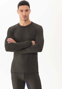 Haut de sport à manches longues en tissu vert olive foncé, doté d'un col rond, de manches raglan et d'un biais contrastant autour du col et des poignets.