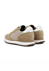 Beige suede and fabric sneakers with pink logo detailing, a white heel tab, and a white midsole, featuring a textured, rubber outsole.
