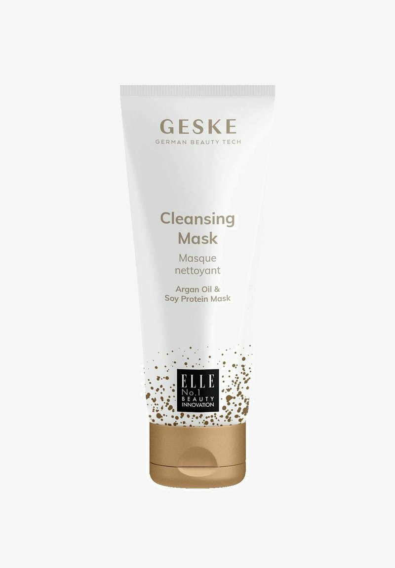 Tube blanche avec une base dorée, étiquetée "Masque Nettoyant." Contient de l'huile d'argan et des protéines de soja, avec des accents dorés et du texte noir.