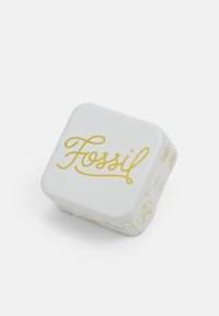 White square tin with rounded corners, featuring gold "Fossil" lettering on top and simple line drawings on the sides.