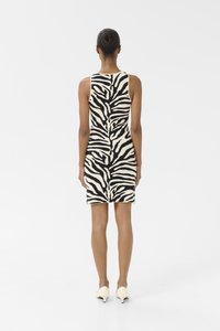 Svartvit zebra-mönstrad klänning, ärmlös, figursydd design, knälång, med en slät yta och kontrasterande färger.