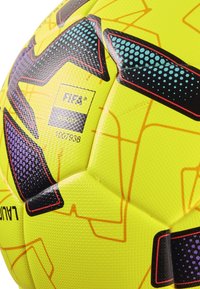 Gul fodbold med en tekstureret overflade, sorte og lilla accenter, geometriske linjemønstre og FIFA-branding.