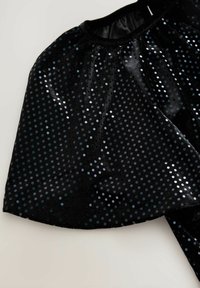 Cape en tissu noir ornée de sequins brillants disposés en motif de points. Possède un col plissé et une texture douce.