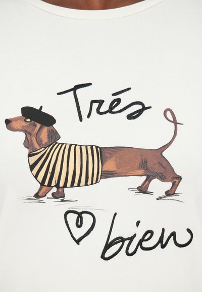 Witte t-shirt met een bruine teckel in een zwarte baret en gestreept shirt, met daaronder de tekst "Très bien" en een hartgrafiek.