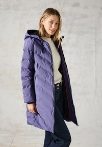 Fialový péřový kabát s diagonálním prošíváním, kapucí a předním zipem. Má kontrastní tmavou podšívku a elastické manžety.