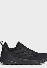 Zwarte Adidas Terrex trail hardloopschoen met een robuuste zool en versteviging op hiel en teen, getoond in het linker zijprofiel tegen een witte achtergrond.