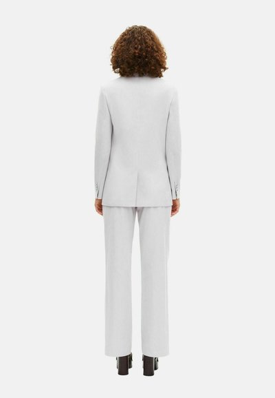 Completo grigio chiaro composto da un giaccone aderente e pantaloni dritti, caratterizzato da una sottile texture e un design minimalista senza motivi visibili.