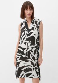 Kurzärmeliges Kleid mit einem schwarz-weißen Blattmuster, aus leichtem Stoff mit lockerer Passform und einem kragenlosen Ausschnitt.