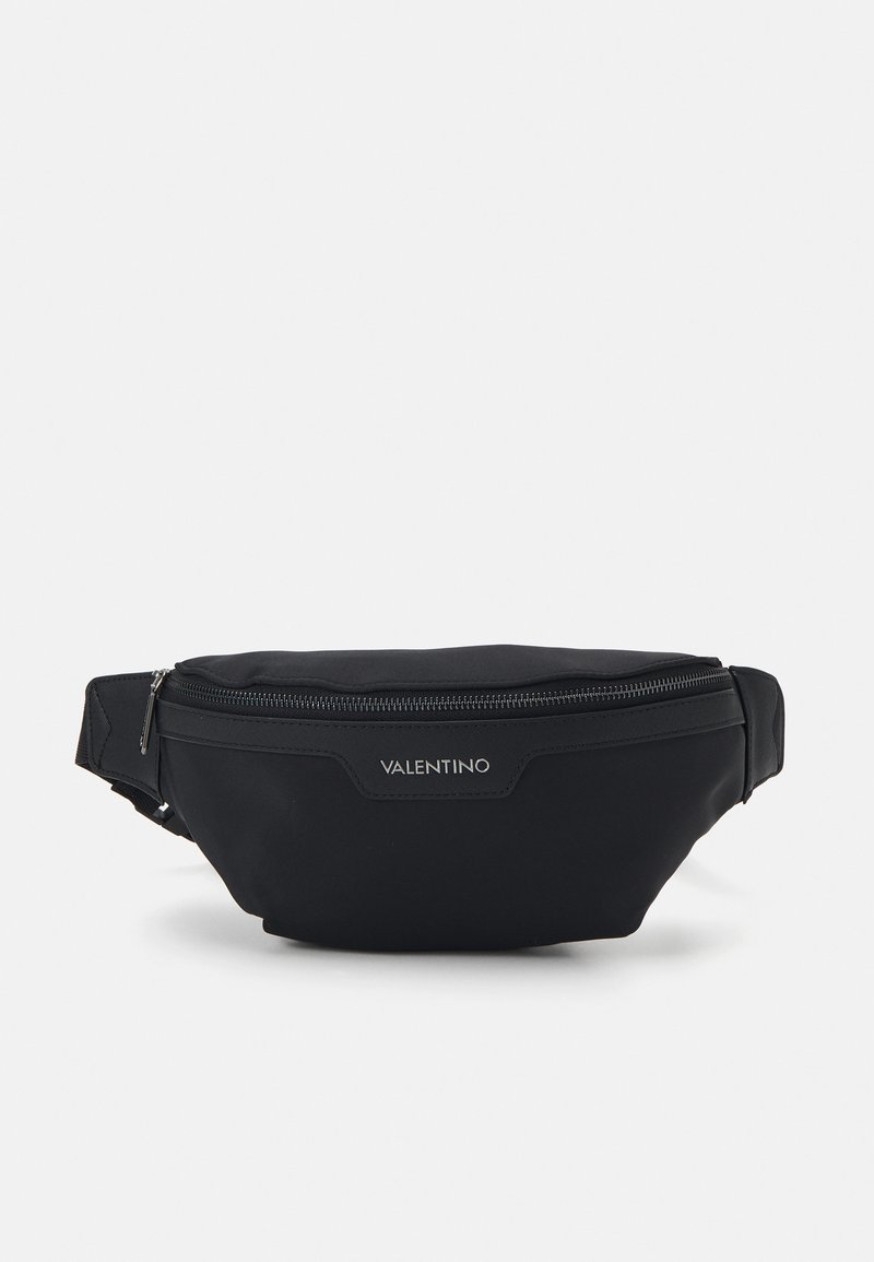 Juodas fanny pack'as, pagamintas iš nailono, su priekiniu užtrauktuku. Yra logotipo plokštelė ir reguliuojama juosta, užtikrinanti saugų prigludimą.