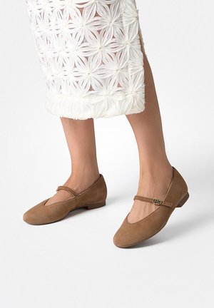 Braune Ballettflats aus Wildleder mit abgerundetem Zehenbereich und einem dekorativen Riemen über dem Spann, ausgestattet mit einem kleinen flachen Absatz und einer glatten Oberfläche.