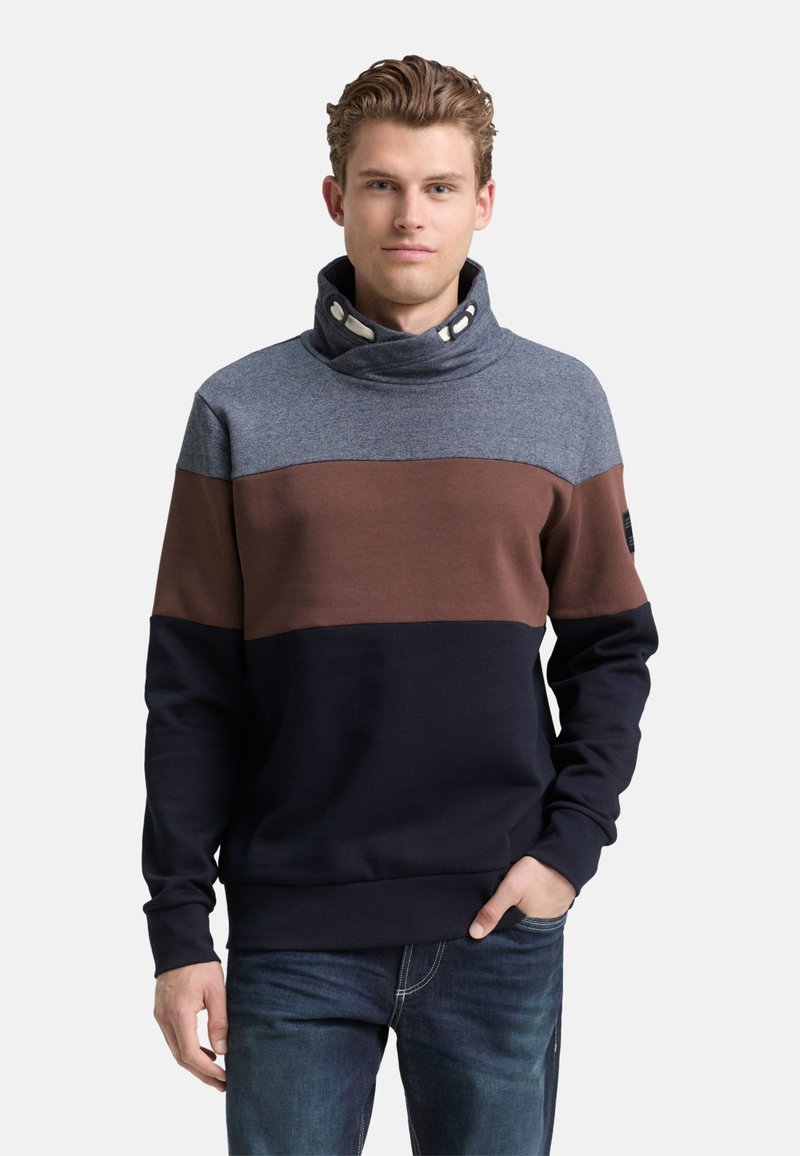 Pullover-Sweatshirt in Blau, Braun und Navy mit Stehkragen, Knopfdetails und weicher Textur. Lässige Passform mit langen Ärmeln.