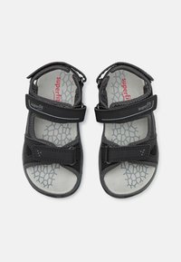 Sorte sandaler med justerbare borrelåser, gummisåler og en grå innersåle med honningkake mønster. Lett og pustende design.
