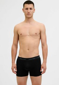 Fekete pamut boxer alsónemű, sima textúrával, márkázott derékkal és testhez simuló kialakítással, férfi modellen bemutatva.