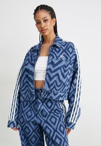 Blauwe denimjas met een textuurpatroon van zigzag, witte strepen op de mouwen, cropped ontwerp. Gecombineerd met bijpassende patroon broeken.