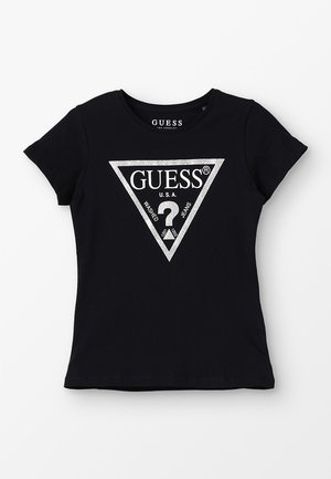 T-shirt Guess nera a maniche corte con logo triangolo argento che presenta la scritta "GUESS U.S.A." e un punto interrogativo all'interno del triangolo.