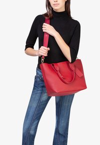 Rode leren handtas met twee handvatten en een afneembare schouderriem. Heeft een gladde afwerking en een rechthoekige vorm, aangevuld met gouden hardware accenten.