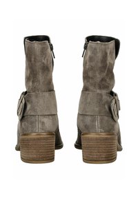 Stivali alla caviglia in suede marrone con punta arrotondata, chiusura con zip e decorazione a fibbia sulla caviglia. Tacco in legno con superficie texture.