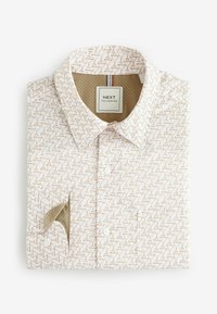 Cămașă albă cu mânecă scurtă, cu un model geometric de pahare de cocktail maro, cu închidere cu nasturi și un buzunar pe piept cu un interior contrastant.