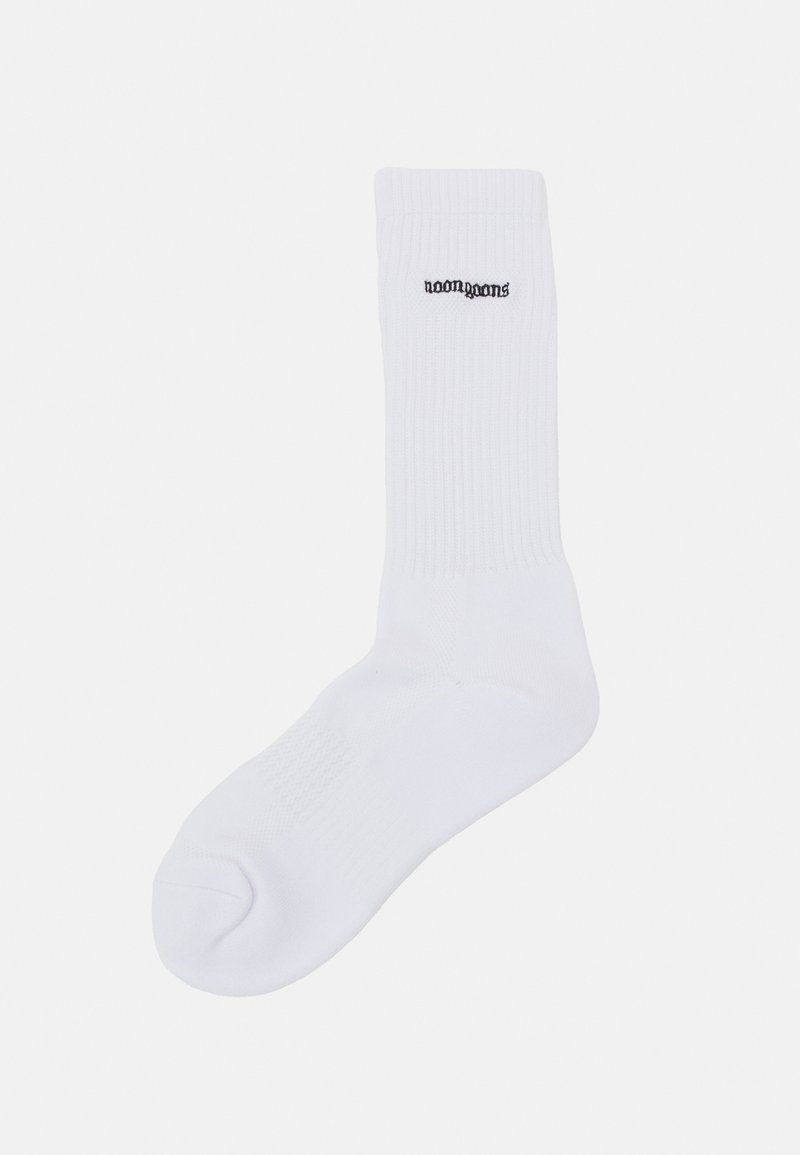 Chaussette en coton blanc avec une texture côtelée, arborant un logo noir imprimé près du haut. Forme standard de chaussette de sport avec un orteil renforcé.