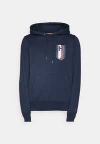 Sudadera azul marino de tejido suave, con un bolsillo frontal, capucha con cordón y un logotipo rectangular con acentos en rojo, blanco y azul.