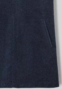 Jupe en velours côtelé bleu marine avec une texture à côtes verticales, une poche latérale et une coupe droite.