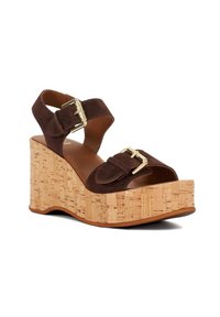 Sandale compensée en suede marron avec plateforme en liège, sangles réglables et accents en boucle dorée. Design à bout ouvert avec un intérieur en cuir lisse.