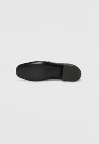 Black leather shoe sole with a smooth, sleek finish, featuring a round toe and a subtle logo imprint on the bottom.