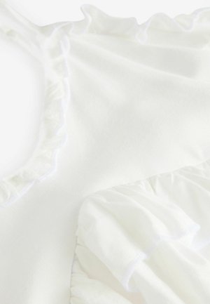 Haut en tissu blanc avec des accents froncés le long de l'encolure et des emmanchures, présentant une texture douce et un drapé léger. Aucun motif ni quincaillerie visible.