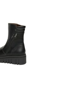 Stivaletto in pelle nera con parte superiore a coste, cerniere laterali e suola in gomma spessa con scanalature per una migliore trazione. Design minimalista.