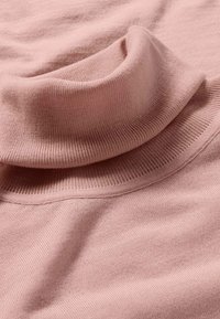 Helles rosa gestricktes Rollkragensweatshirtgewebe mit sichtbarer feiner Rippung und gefaltetem Kragen.