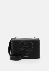 Svart axelremsväska i konstläder med guldfolierad "Love Moschino"-logotyp och hjärtdesign, med vita sömmar och avtagbar rem.