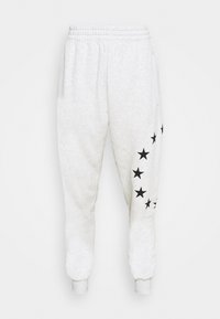 Ljusgrå mjukisbyxor med ett svart stjärnmönster längs sidan, elastisk midja och avsmalnande muddar. Mjukt material i bomullsblandning.