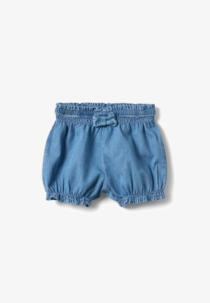 Pantalones cortos para niños pequeños de color azul claro con cintura elástica, bordes con volantes y un pequeño lazo de tela centrado en la cintura sobre un fondo blanco.