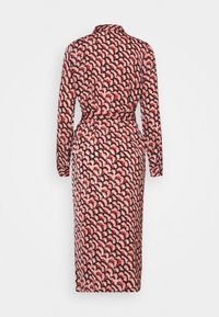 Robe à manches longues avec col, présentant un motif ondulé rouge et noir sur un fond clair, avec une ceinture à nouer à la taille.