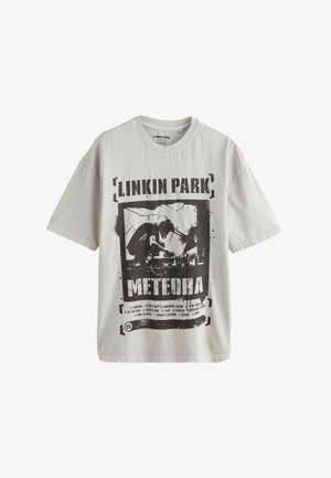 Maglietta grigia chiara in cotone, con una stampa grafica nera con il testo "Linkin Park" e "Meteora", insieme a un design astratto.