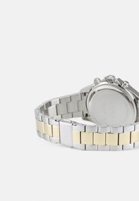 Orologio in tonalità argento e oro con bracciale in acciaio inossidabile e dettagli dorati, cassa rotonda e tre pulsanti cronografi.