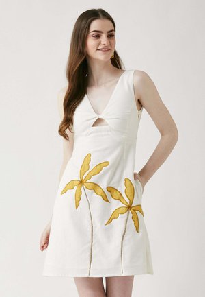 Weißes Kleid mit V-Ausschnitt und Ausschnitt an der Brust, verziert mit gelb gestickten Palmblättern und minimalen Details.
