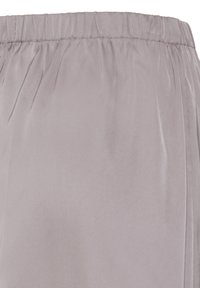 Pantalon gris clair avec ceinture élastique, tissu lisse et détails subtils de coutures, présenté en gros plan au niveau de la taille.