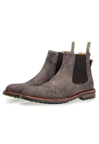Bottes Chelsea en cuir marron texturé avec panneaux latéraux élastiques, languettes vertes et semelles en caoutchouc dotées d'un motif antidérapant.