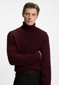 Bordeaux kabelbrei turtleneck trui, met een gestructureerd patroon, geribbelde kraag en manchetten, in een ontspannen pasvorm en met een iets verkorte lengte.