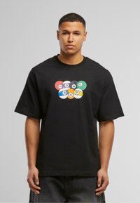 Camiseta de algodón negra de manga corta con un colorido diseño gráfico de bolas de billar y el texto "HOME BOY" en el centro.