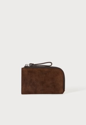 Braune Veloursleder-Handgelenktasche mit Reißverschluss und Lederschlaufenverschluss auf einem einfarbig hellen Hintergrund.