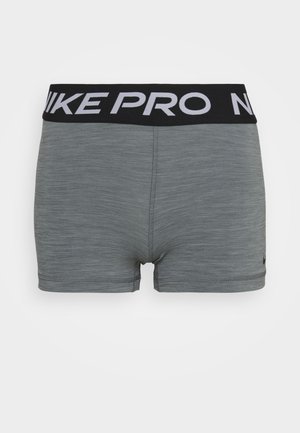 Shorts de sport gris avec une taille noire portant les lettres blanches "NIKE PRO". Le matériau a une apparence texturée ; les shorts sont ajustés.