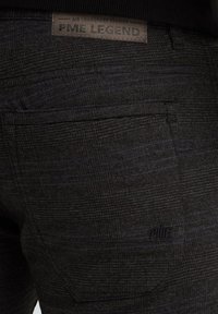 Zwarte stoffen broek met een subtiel blauw ruitpatroon. Heeft een leren label met 'PME Legend' op de achterkant.