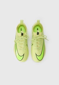 Zapatillas deportivas verdes y amarillas con un diseño elegante, que presentan acentos del logo de Nike en negro y agujetas planas. Parte superior de material sintético texturizado.