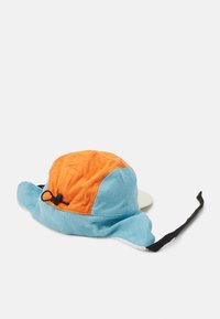 Bucket hat made of corduroy in blue and orange. Features a wide brim, adjustable strap, and a solid beige underside. Textured surface.