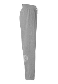 Grå sweatpants med elastisk talje, snor, sidelommer og et K-logo på underbenet, der har en blød tekstur.